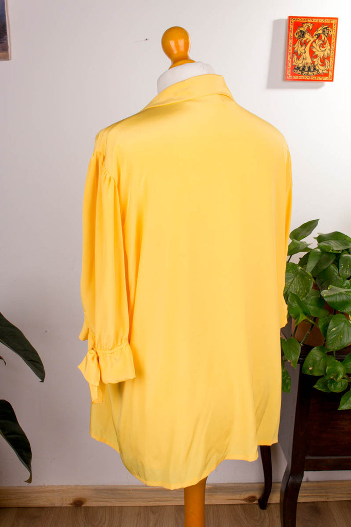 elegante Bluse aus warmem sonnengelbem Stoff mit seidigem Schimmer,  Knopfleiste, großer Kragen, Brusttaschen. Original 90er-Jahre!